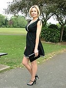 Hot Milf Monica posing in a gorgeous short black dress with matching shiny high heels